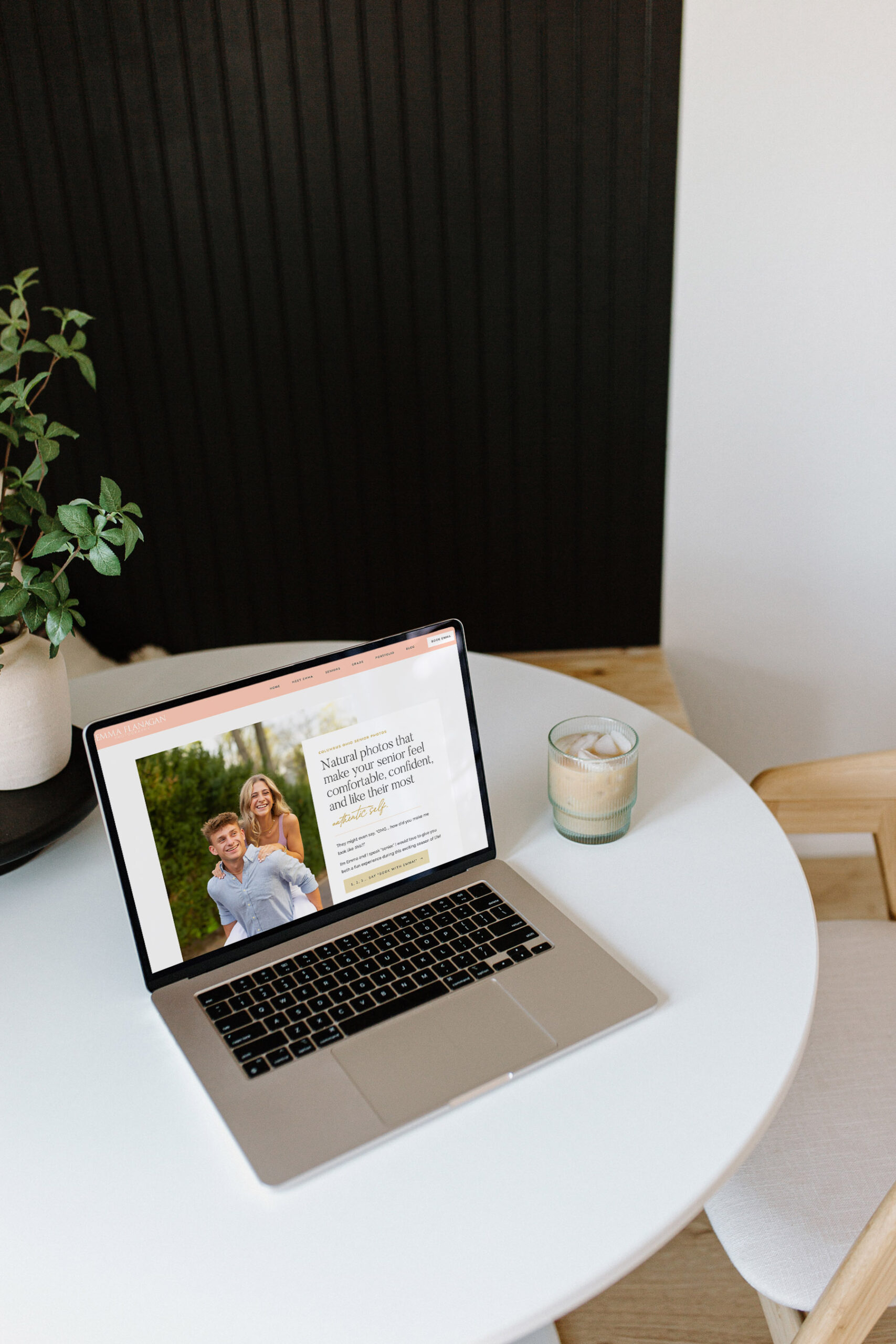 Laptop open showing a Showit template customization for a senior photographer