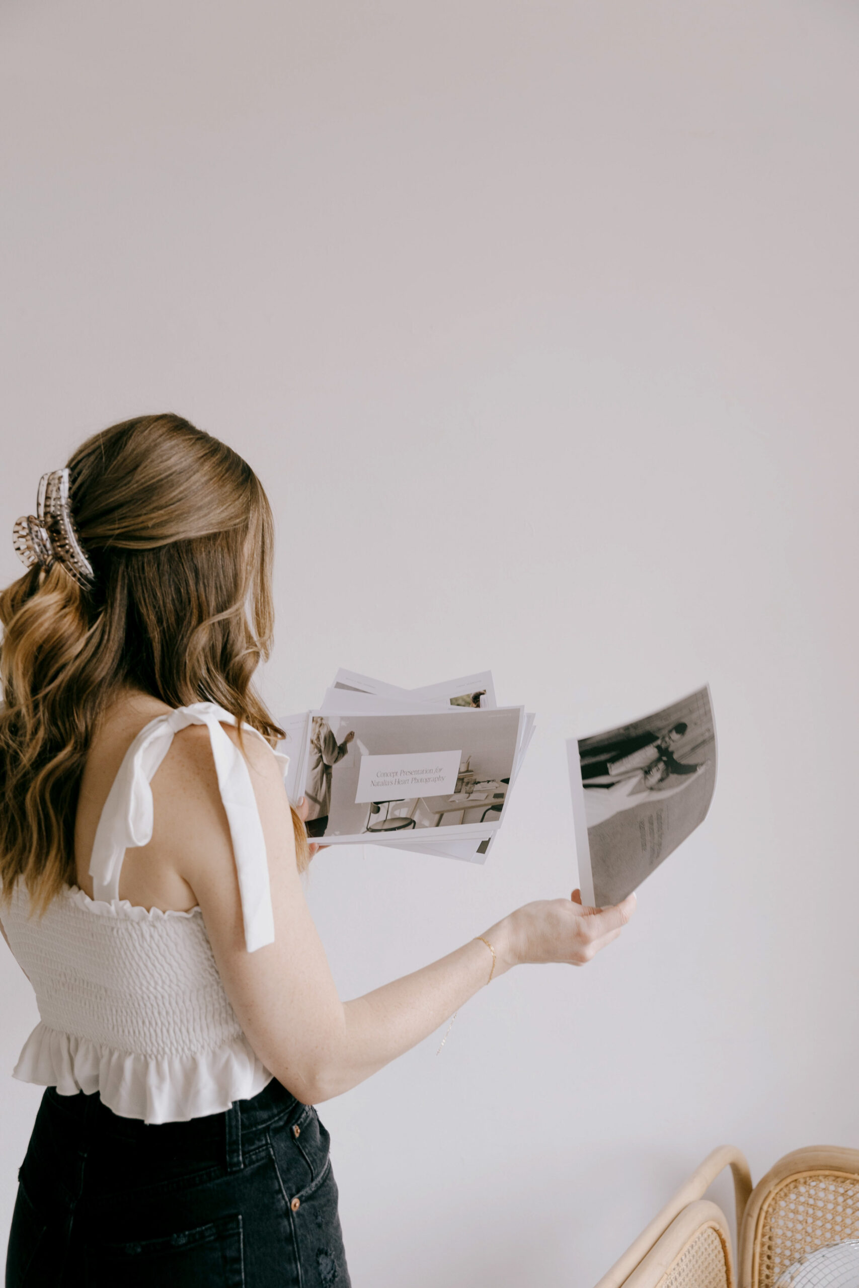 Creative woman reviewing printed design concepts while planning a website using Showit + WordPress Blog Integration.