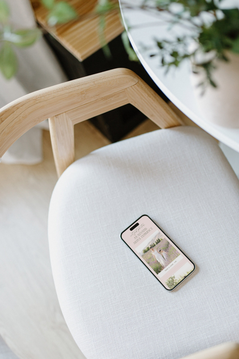 Phone showing website on chair, highlighting mobile design in the Showit vs Squarespace comparison and website builder for photographers.